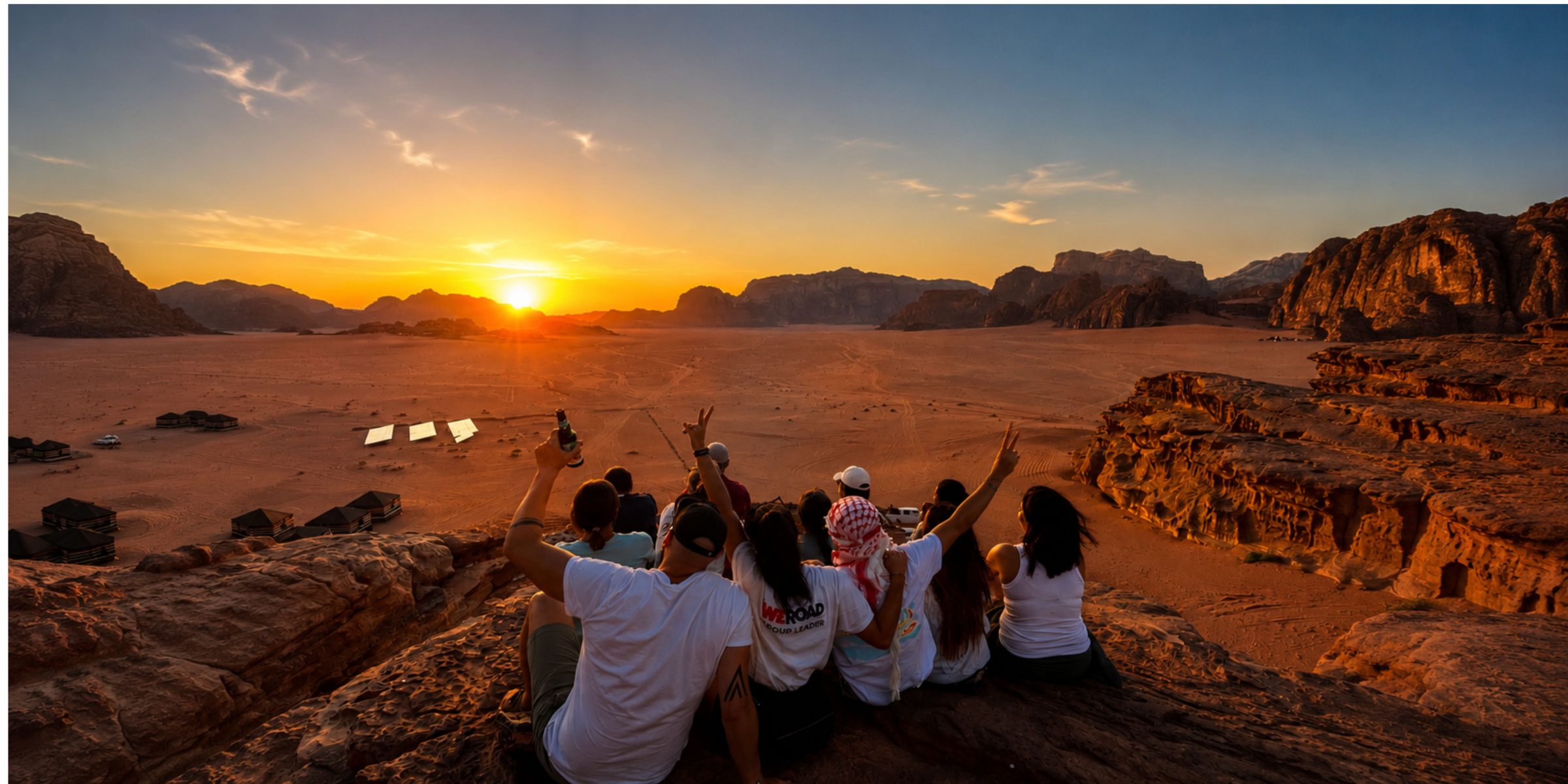 Grupo de viajeros WeRoad viendo el atardecer en el desierto de Wadi Rum